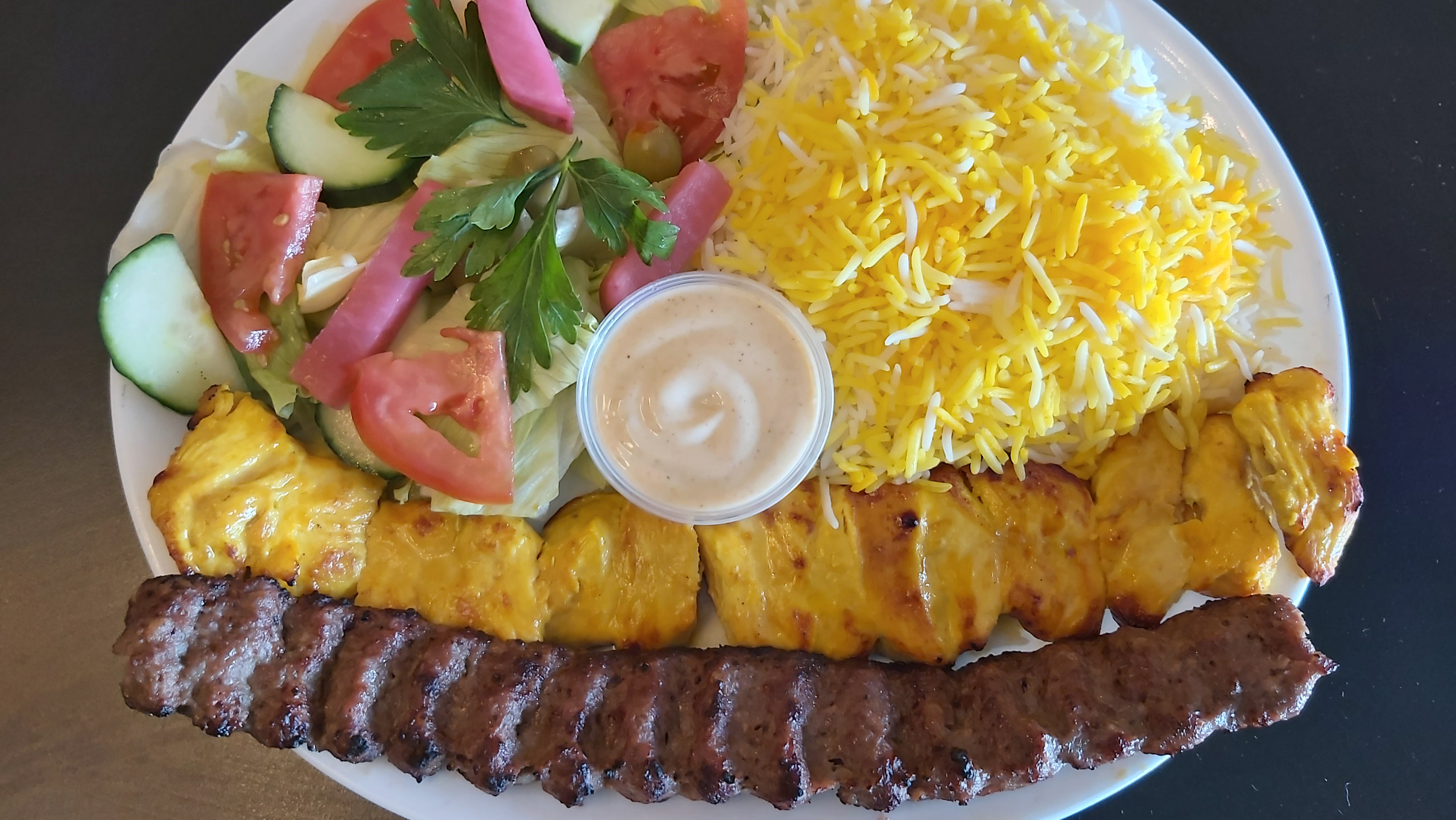Grilled chicken and Koobideh kebab with sauce, rice, and salad